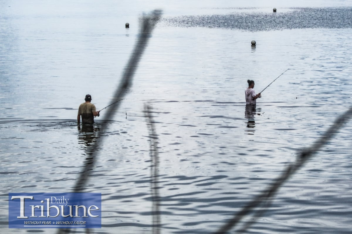 Men are seen catching fish in Mabua Beach in Tandag City, Surigao del Sur on 17 June 2024.
